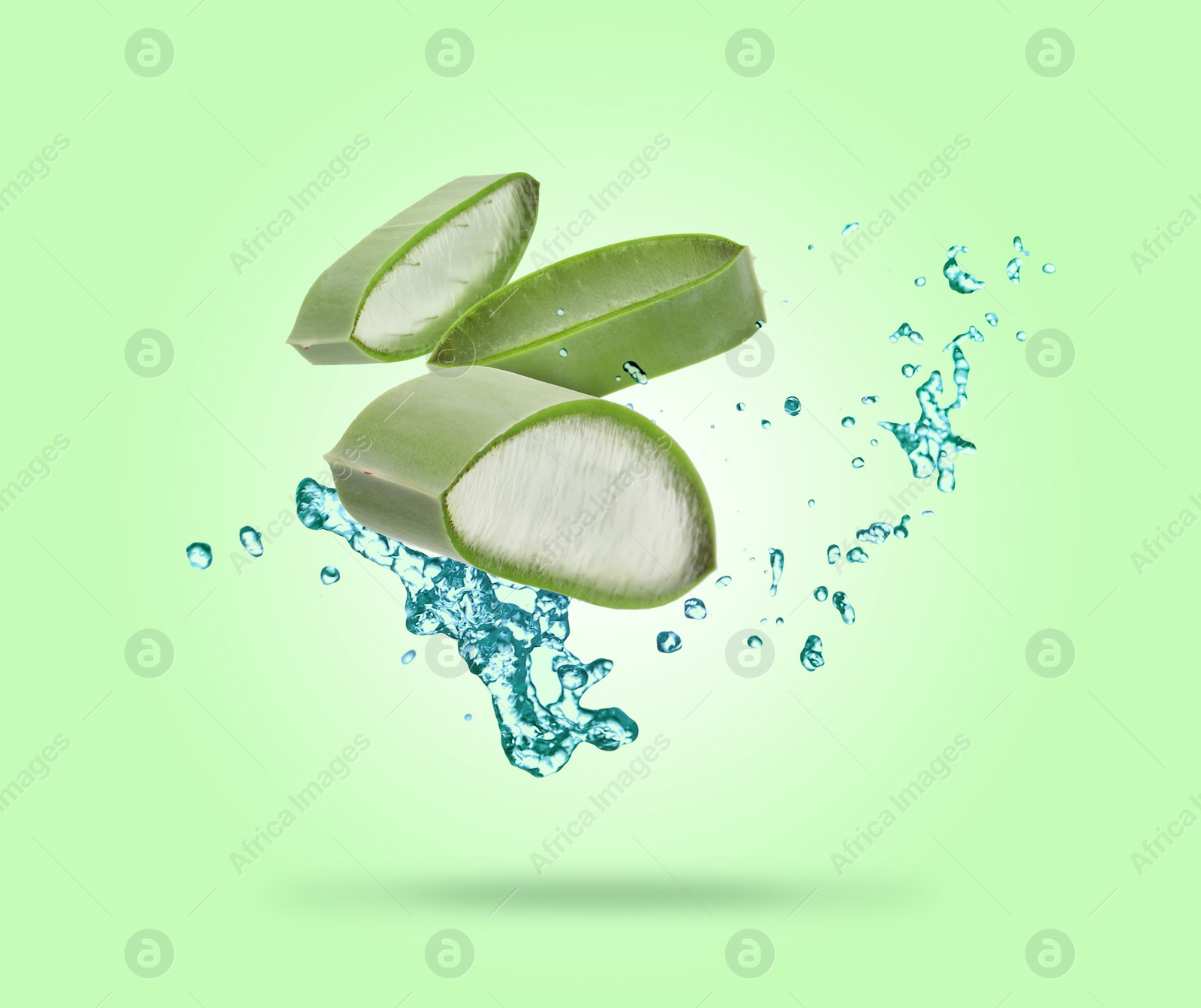 Image of Sliced aloe vera leaf and splashes of juice on green background