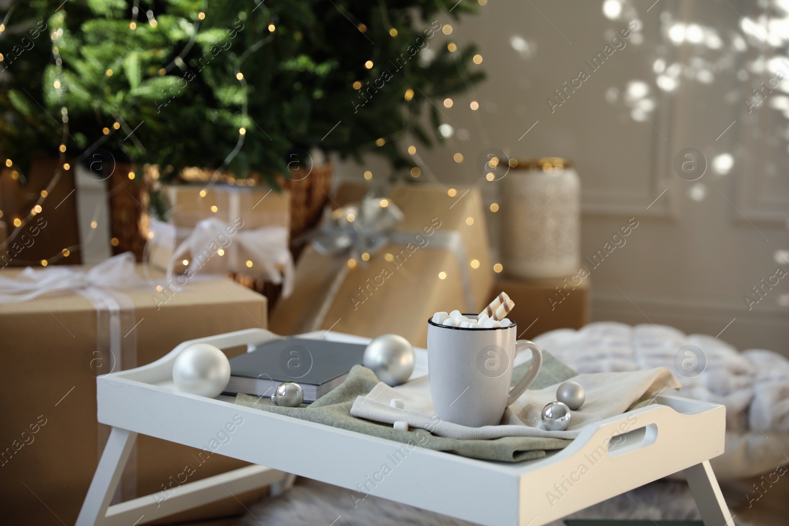 Photo of Cup of cocoa, book and balls on tray at home. Christmas celebration