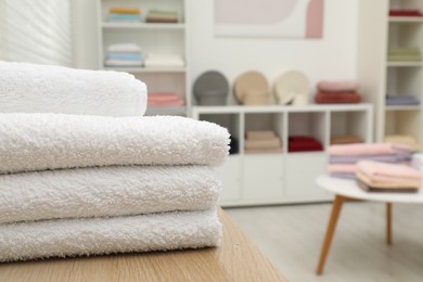 Photo of Stack of white towels in home textiles store, closeup. Space for text