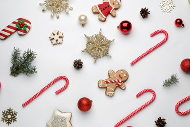 Flat lay composition with sweet candy canes and Christmas decor on white background