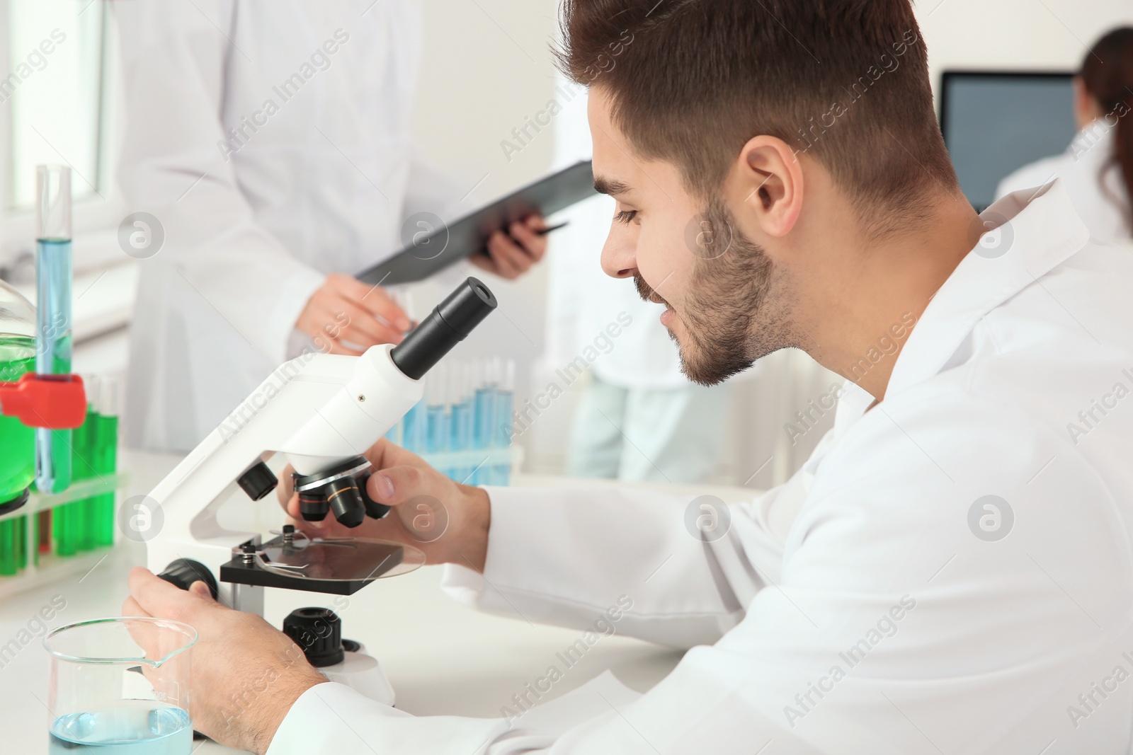 Photo of Medical student working with microscope in modern scientific laboratory