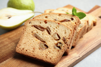 Photo of Slices of tasty pear bread on wooden board, closeup. Homemade cake