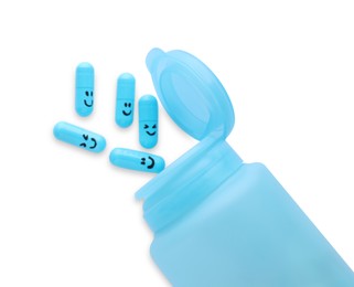 Bottle and antidepressant pills with funny faces on white background, top view