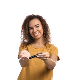 Photo of Young African-American woman using lancet pen on white background. Diabetes control