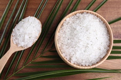 Photo of Flat lay composition with white sea salt on wooden background. Spa treatment