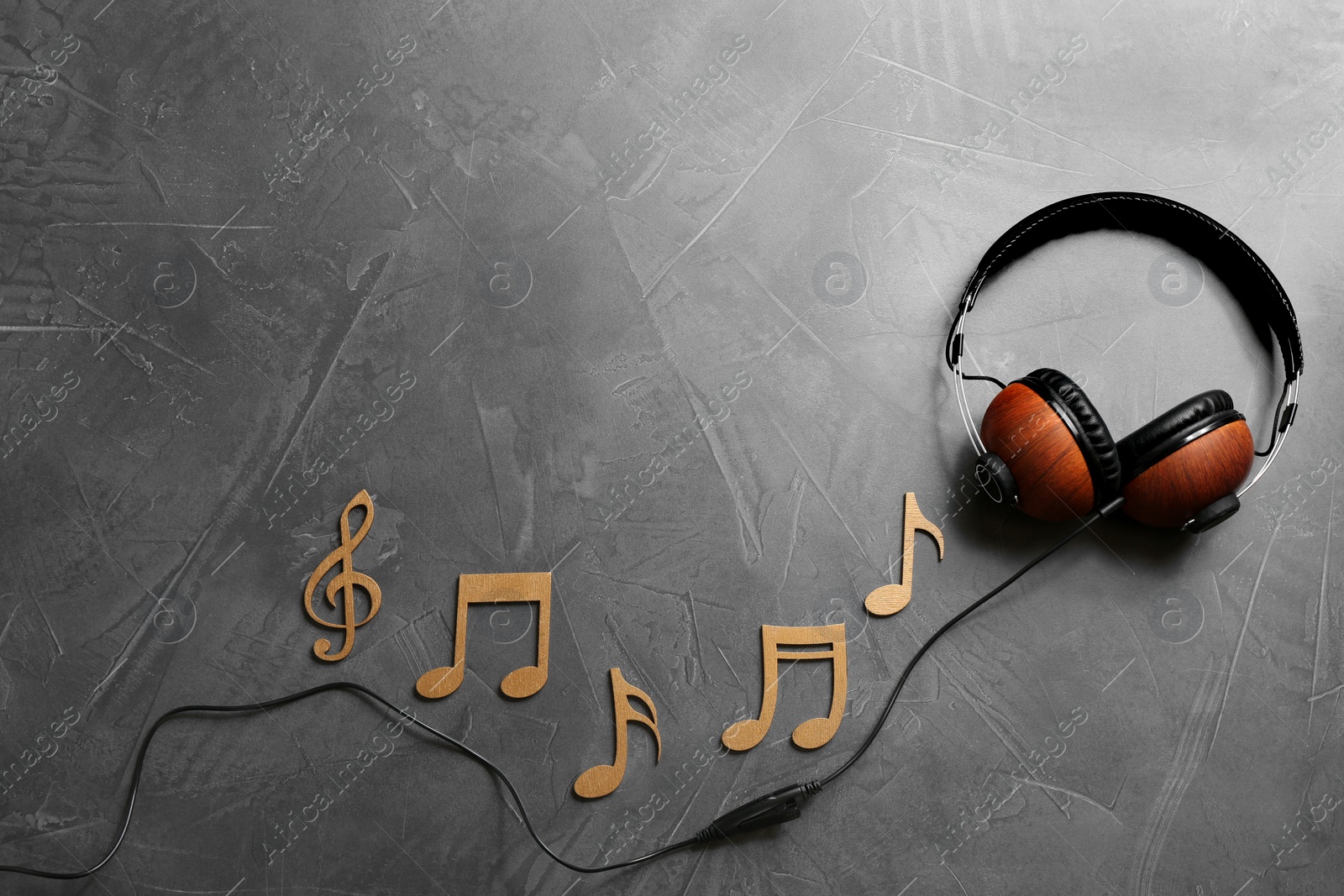 Photo of Flat lay composition with music notes, headphones and space for text on grey background