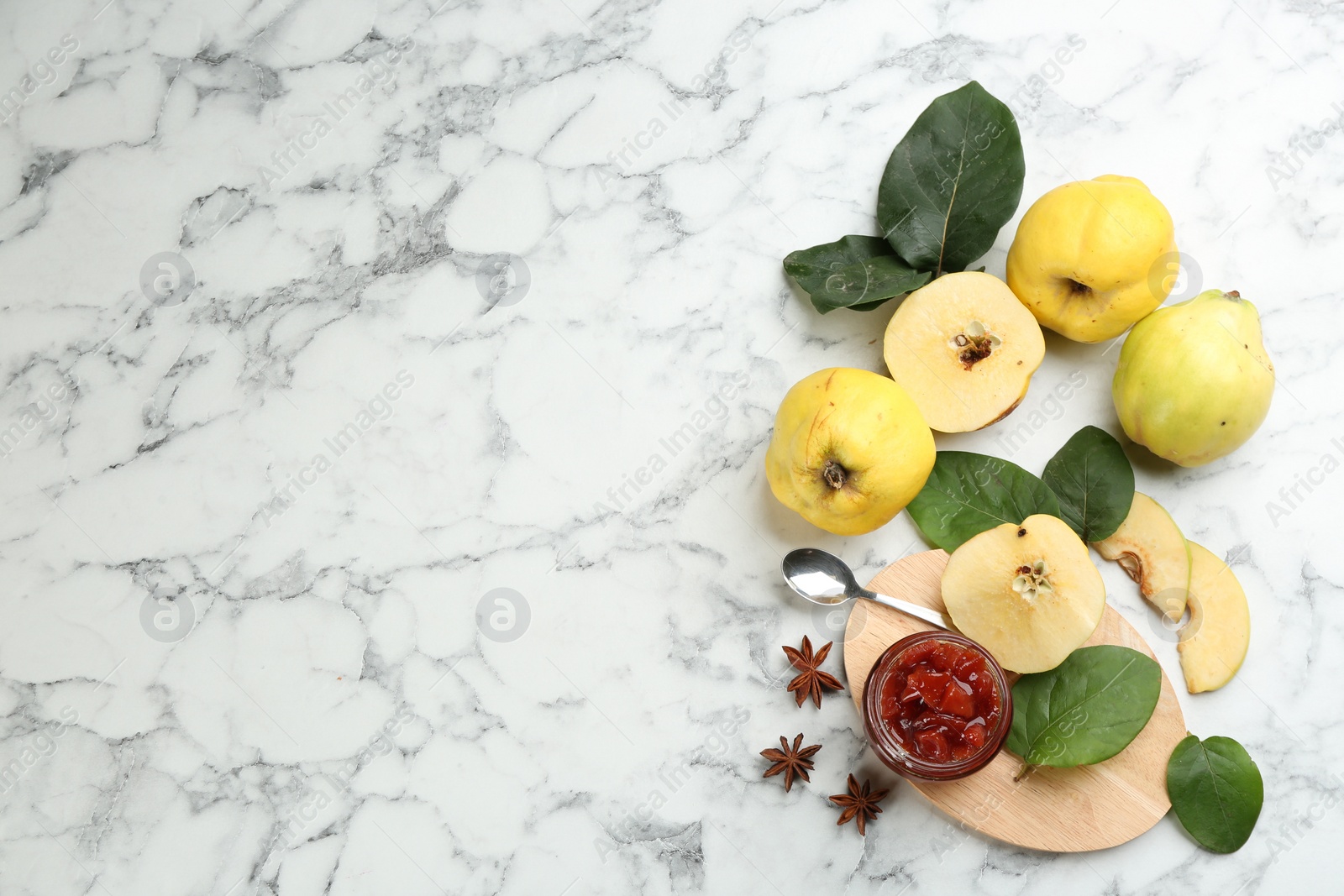 Photo of Delicious quince jam and fruits on white marble table, flat lay. Space for text