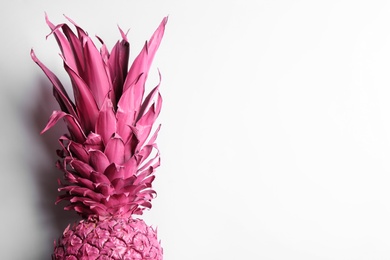 Painted pink pineapple on white background, top view. Creative concept