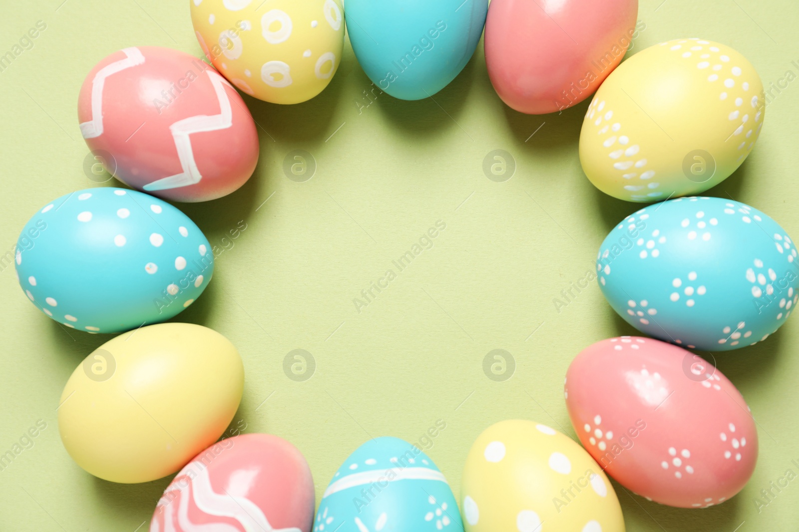 Photo of Flat lay composition of painted Easter eggs on color background, space for text