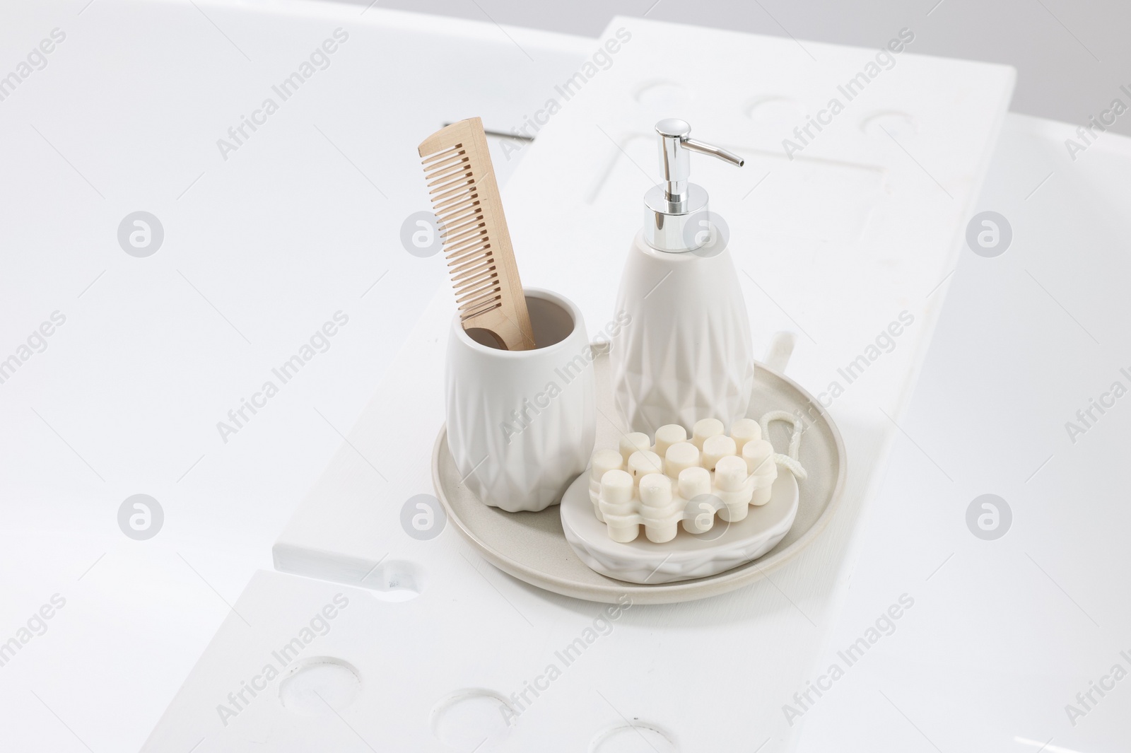 Photo of Different personal care products and accessories on bath tub in bathroom