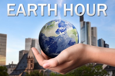 Image of Take care of Earth, turn off lights for hour. Woman holding illustration of planet outdoors, closeup