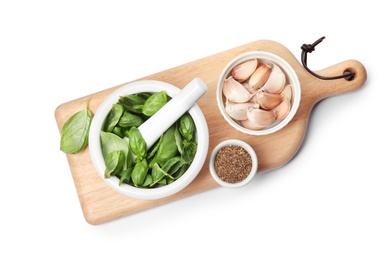 Photo of Mortar with fresh green basil leaves and bowls of spices on white background, top view