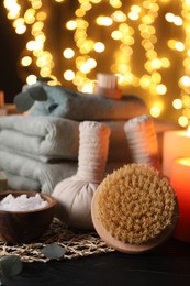 Beautiful composition with different spa products on table against blurred lights