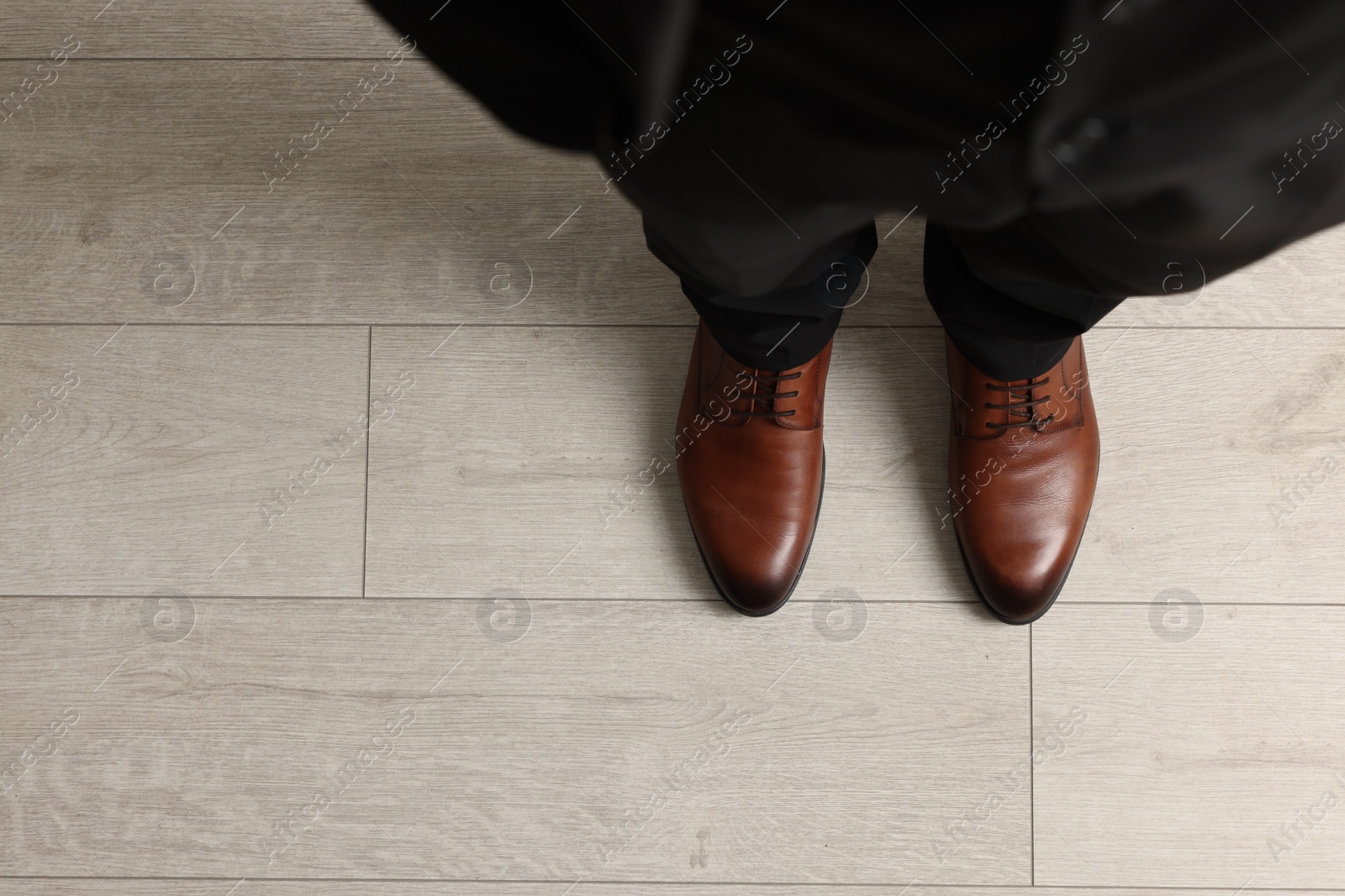 Photo of Businessman in elegant leather shoes on floor, above view. Space for text