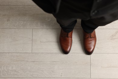 Businessman in elegant leather shoes on floor, above view. Space for text