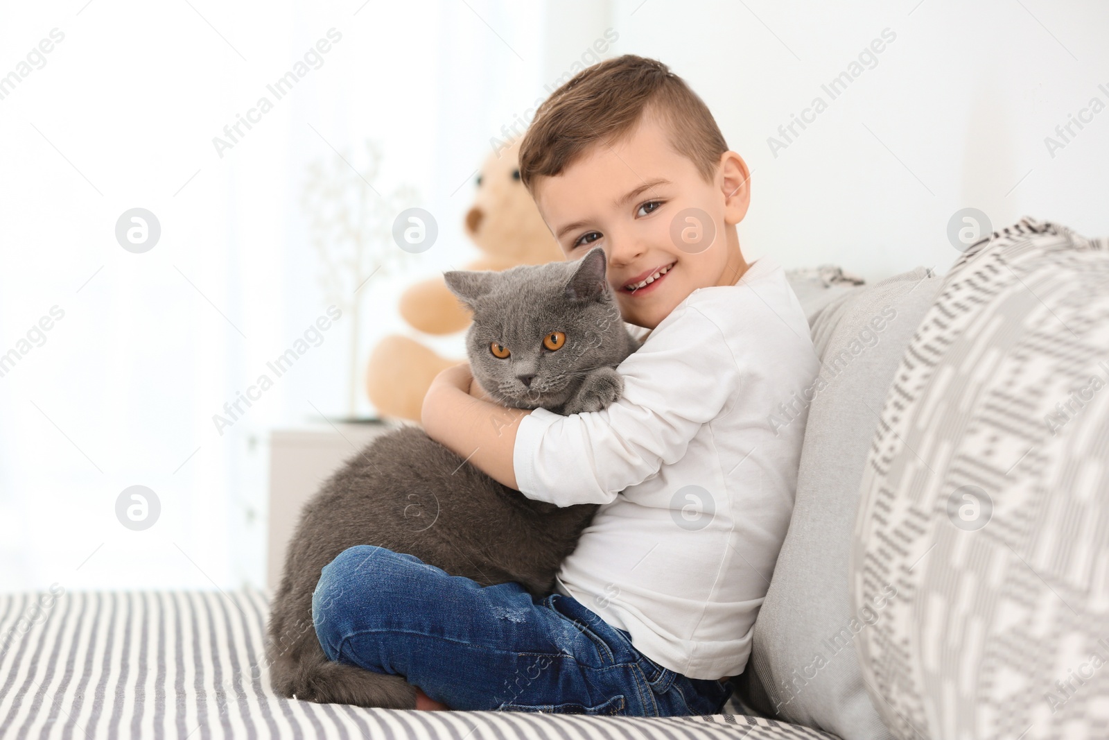 Photo of Cute little child with cat at home