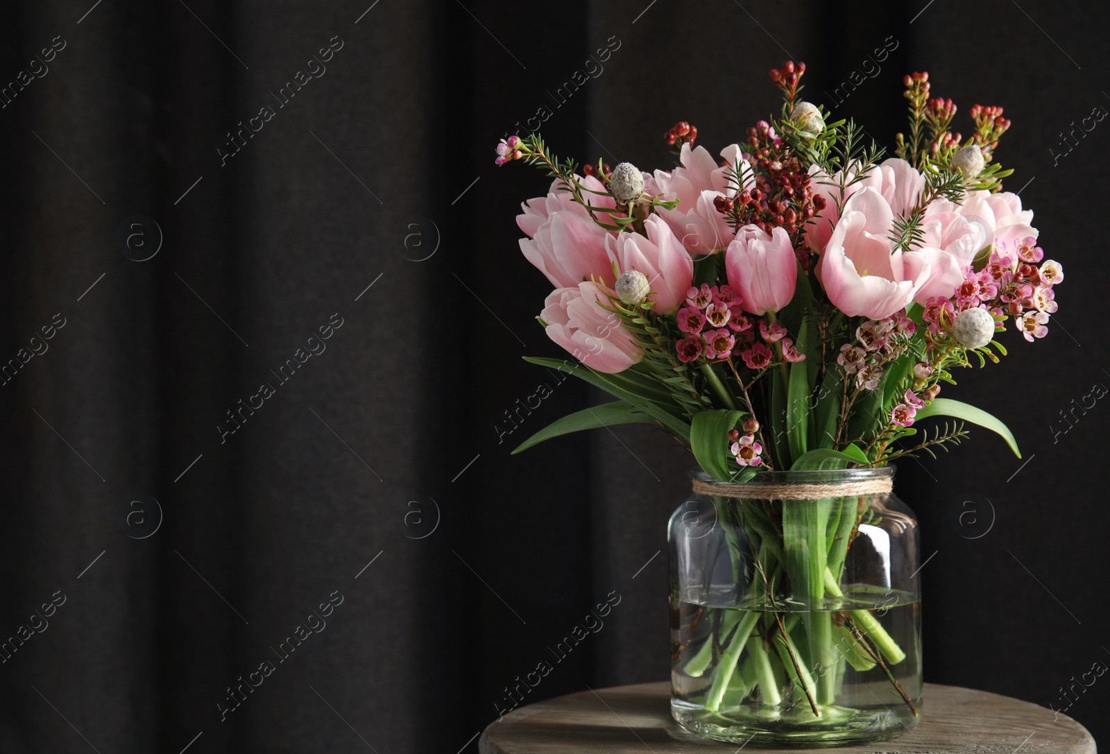 Photo of Beautiful bouquet with spring pink tulips on wooden table. Space for text