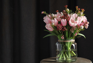 Photo of Beautiful bouquet with spring pink tulips on wooden table. Space for text