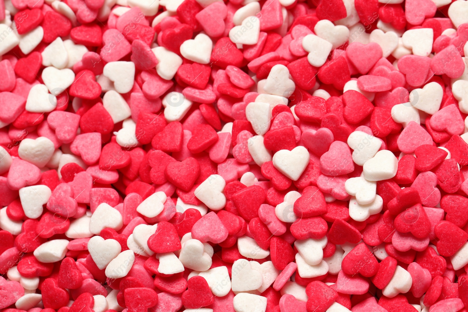 Photo of Sweet candy hearts as background, top view