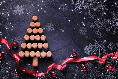 Christmas tree made of wine corks and decor on dark stone background, flat lay