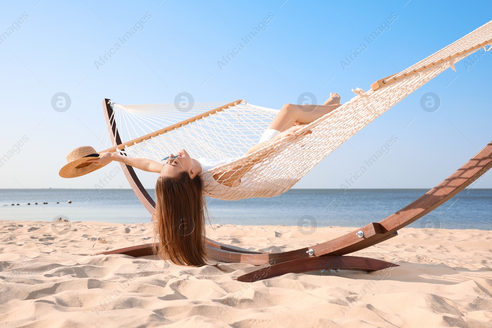 Photo of Young woman relaxing in hammock on beach