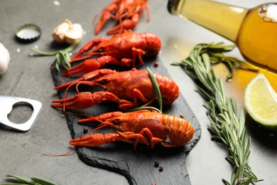 Photo of Delicious red boiled crayfishes on black table, closeup