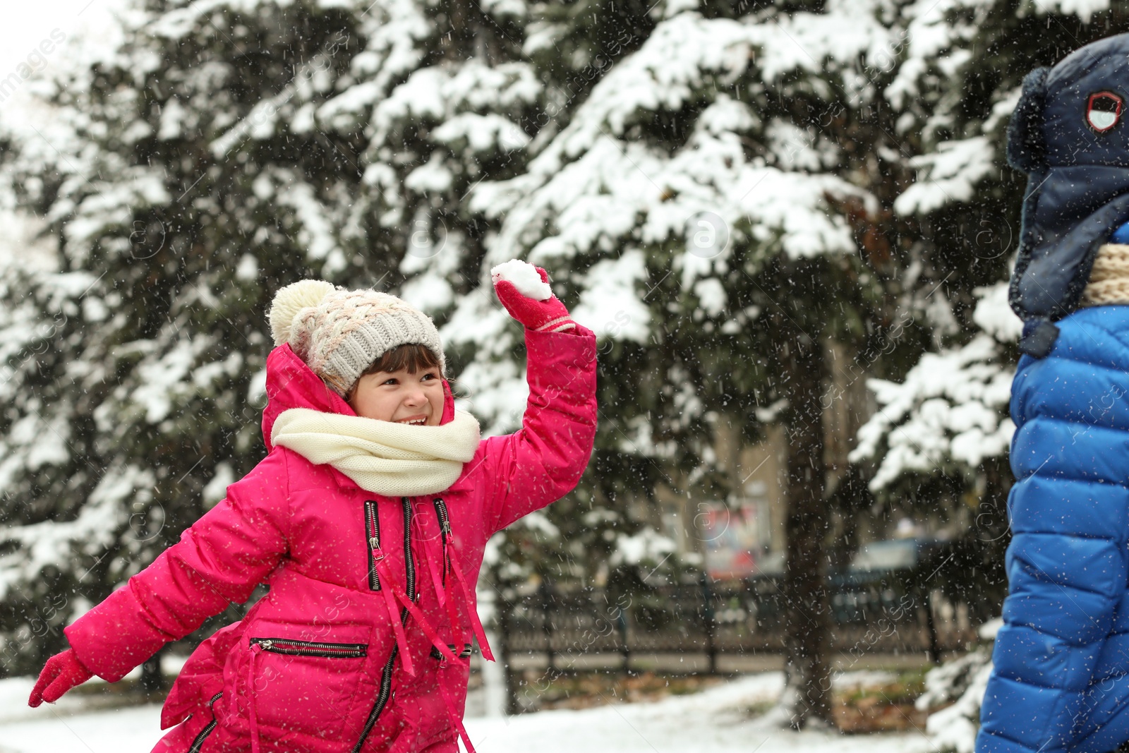 Photo of Little children playing with snow outdoors on winter day