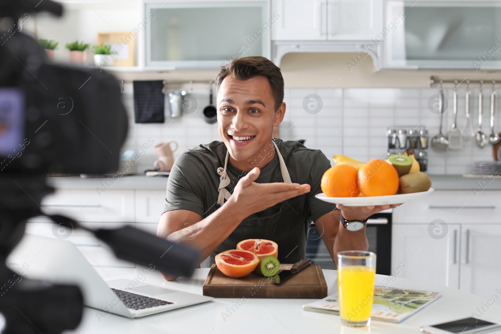 Photo of Food blogger recording video on camera in kitchen