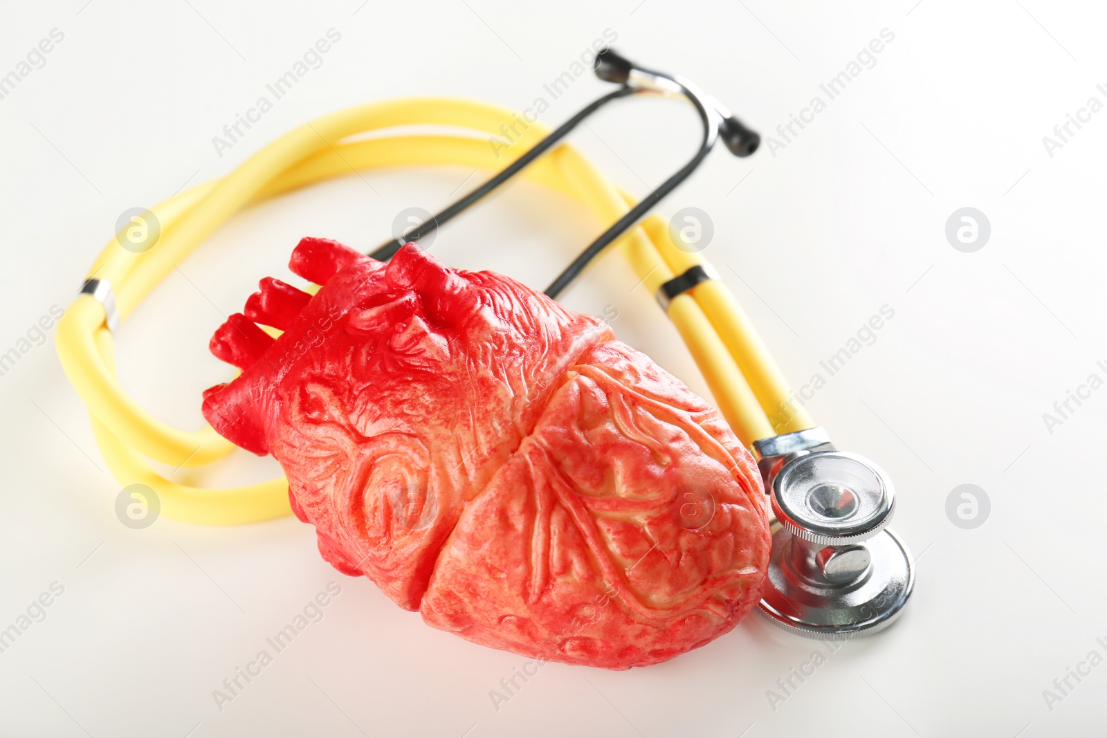 Photo of Stethoscope and model of heart on table. Heart attack concept