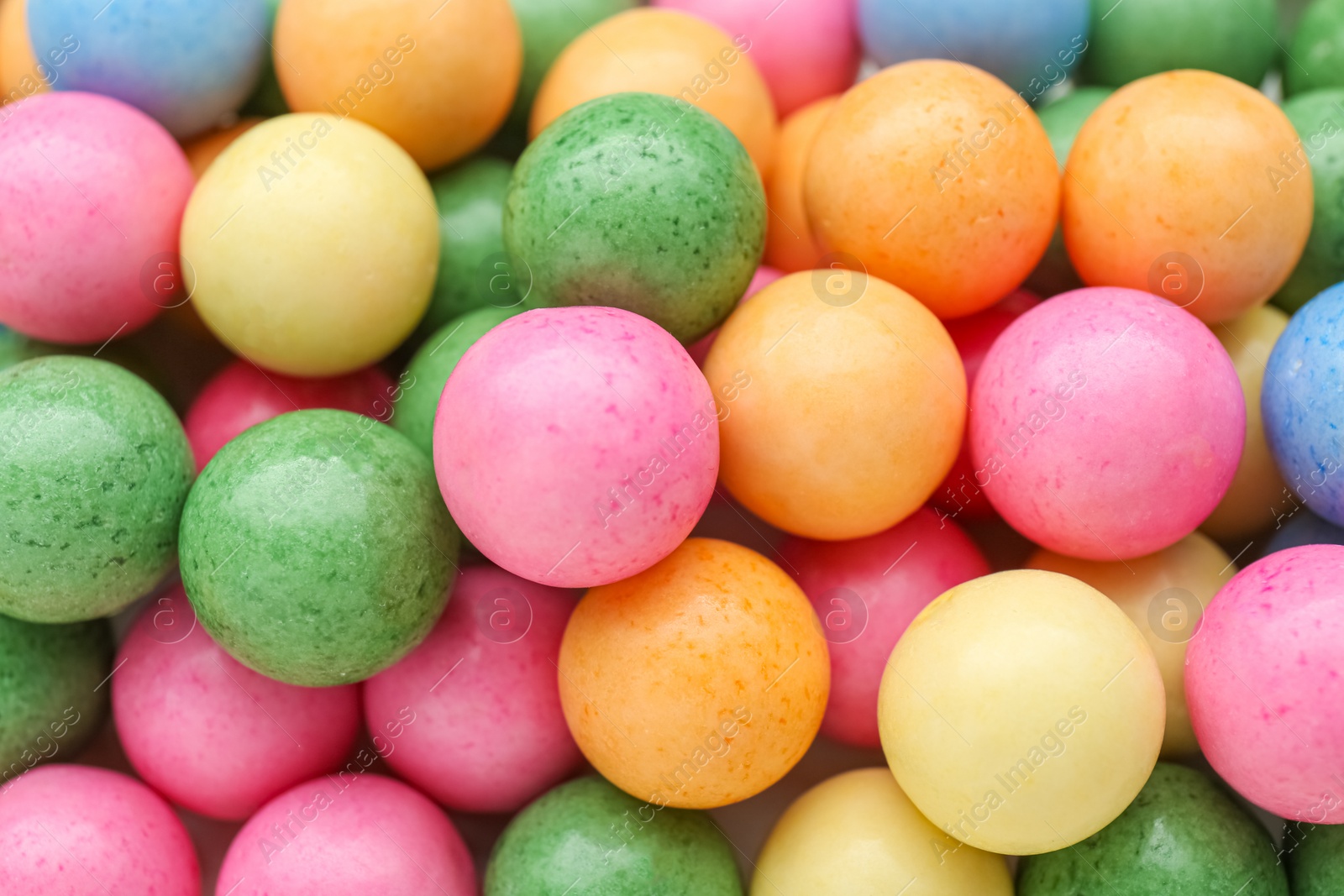 Photo of Many bright chewy gumballs as background, top view