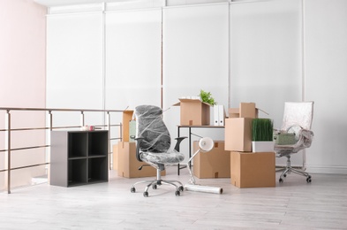Photo of Carton boxes with stuff in room. Office move concept