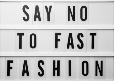 Photo of Lightbox with phrase SAY NO TO FAST FASHION as background, top view