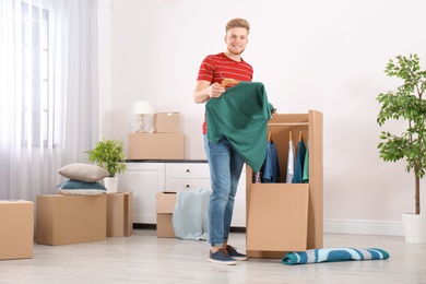 Young man near wardrobe box at home