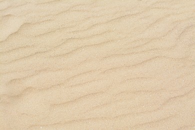 Photo of Dry beach sand with wave pattern as background