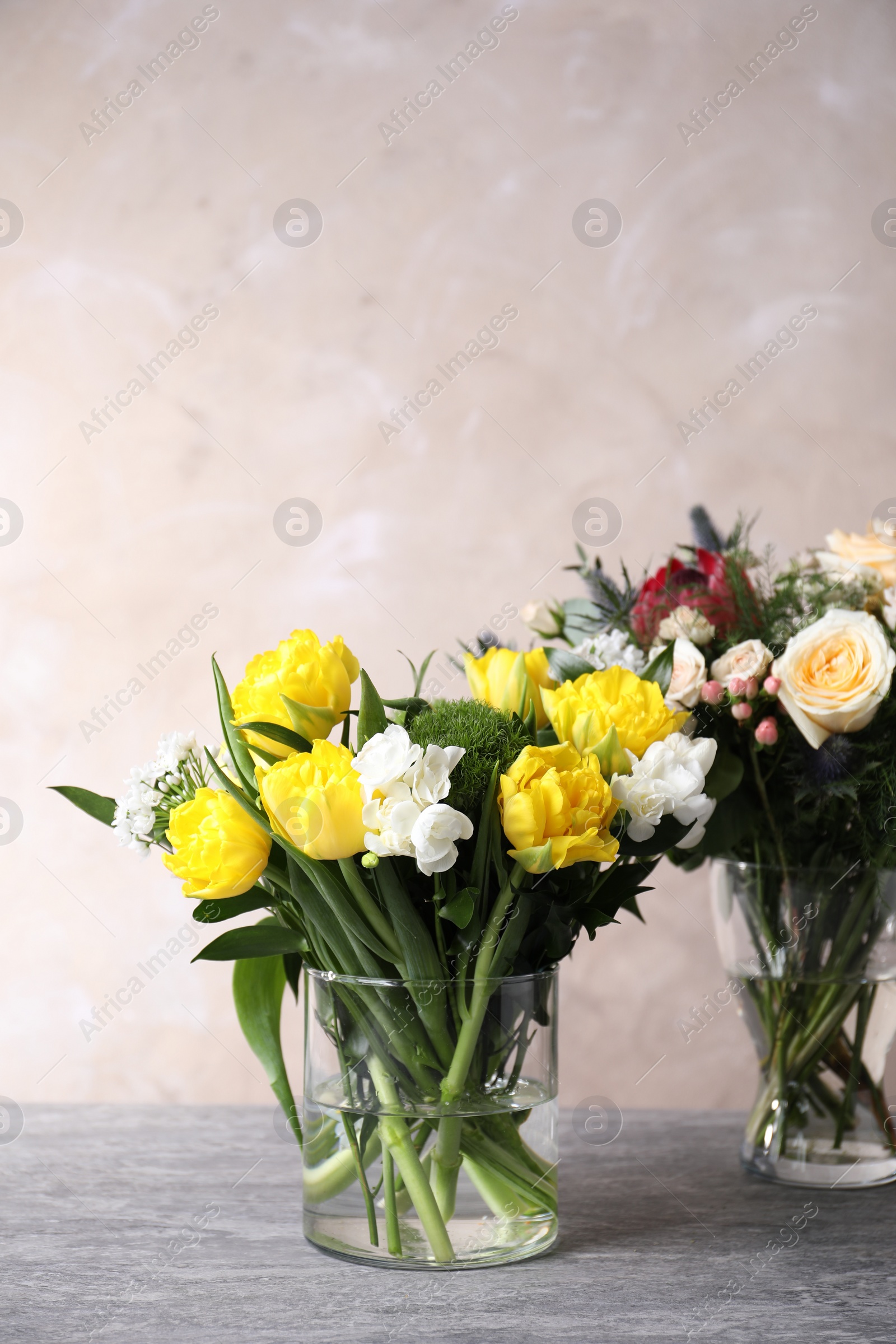 Photo of Beautiful bouquets with fresh flowers on grey table