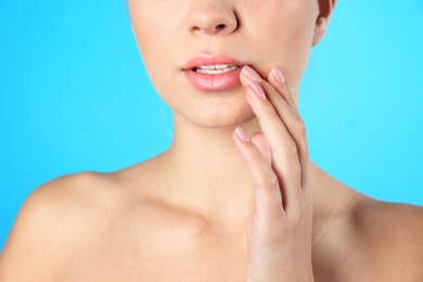 Closeup view of beautiful young woman on color background. Lips contouring, skin care and cosmetic surgery concept