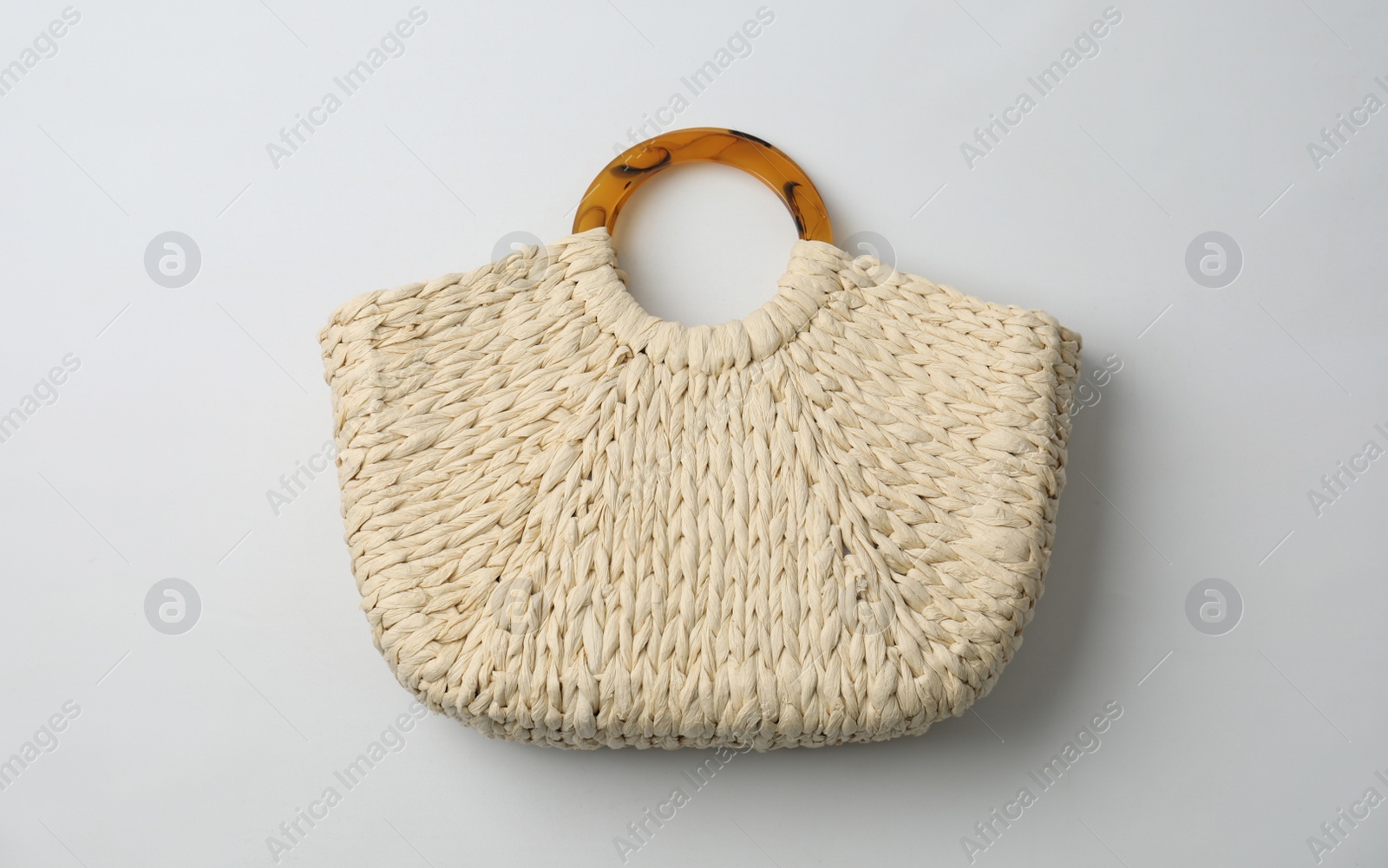 Photo of Stylish straw bag on white background, top view. Summer accessory
