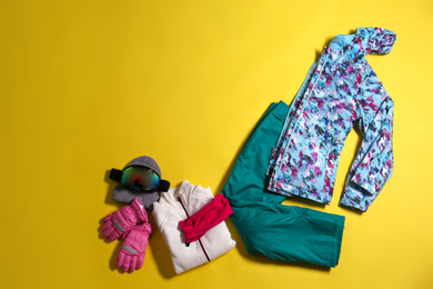 Photo of Stylish winter sport clothes on yellow background, flat lay