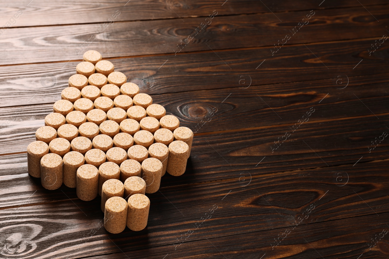 Photo of Christmas tree made of wine corks on wooden table. Space for text