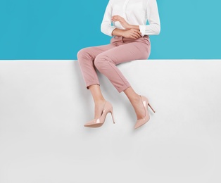 Photo of Woman wearing stylish shoes on color background, closeup