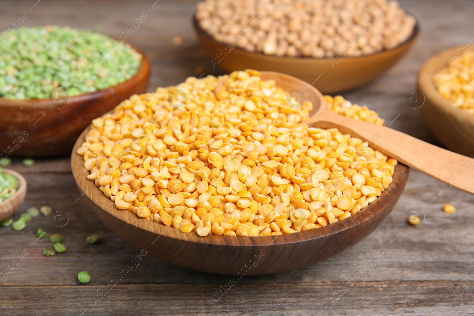 Photo of Bowl with dried peas on wooden table