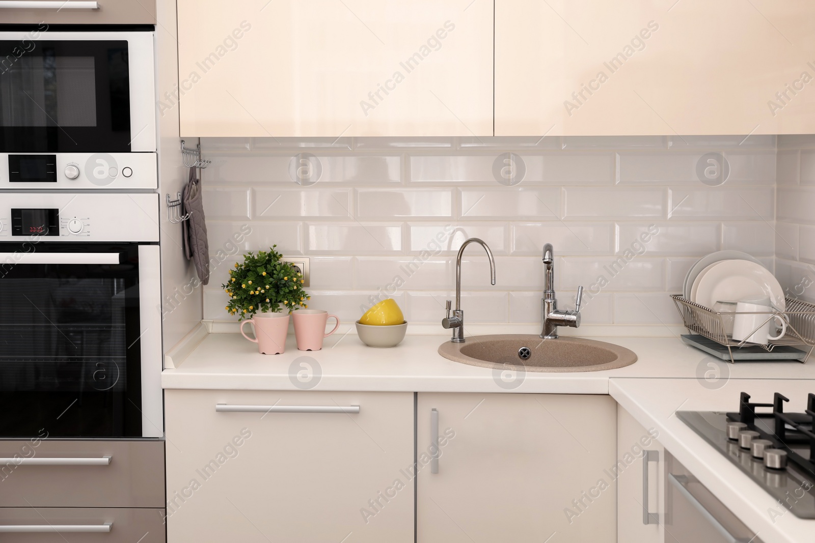 Photo of Stylish kitchen interior with modern oven and microwave