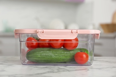 Box with fresh raw vegetables on table in kitchen