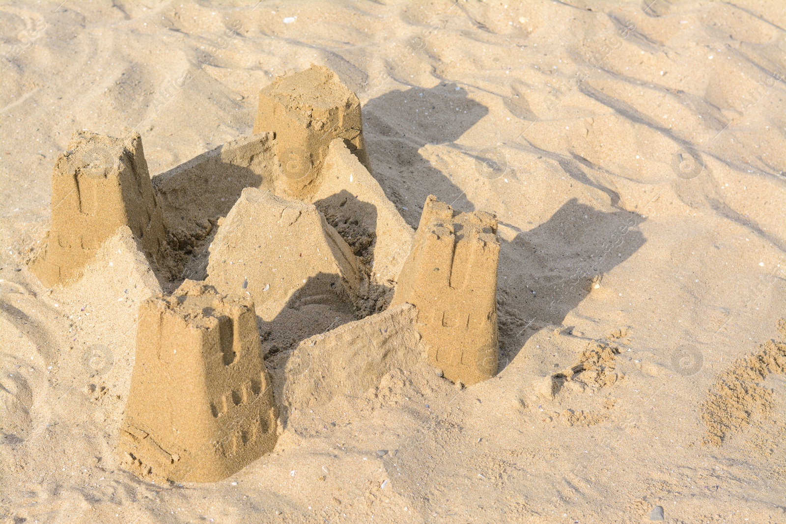 Photo of Beautiful sand castle on beach. Space for text