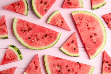 Photo of Slices of ripe watermelon on pink wooden table, flat lay