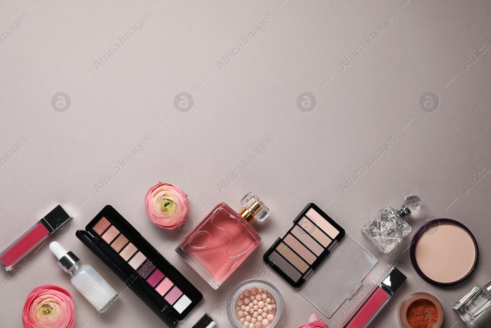 Photo of Flat lay composition with different makeup products and beautiful spring flowers on grey background. Space for text