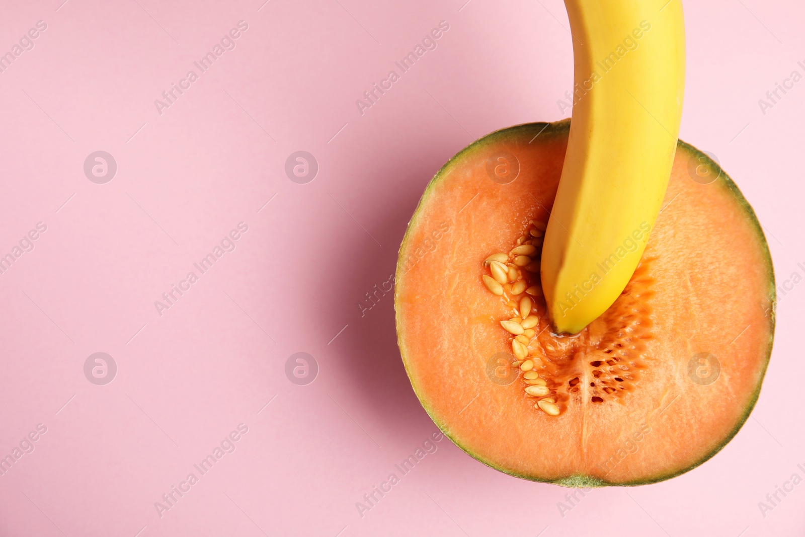 Photo of Flat lay composition with fresh banana and melon on pink background, space for text. Sex concept