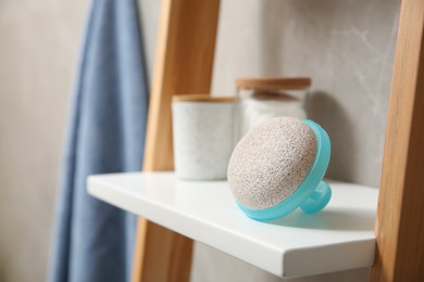 Photo of Pumice stone on white shelf in bathroom, space for text
