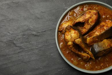 Photo of Tasty fish curry on grey textured table, top view. Space for text. Indian cuisine
