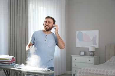 Man listening to music while ironing at home